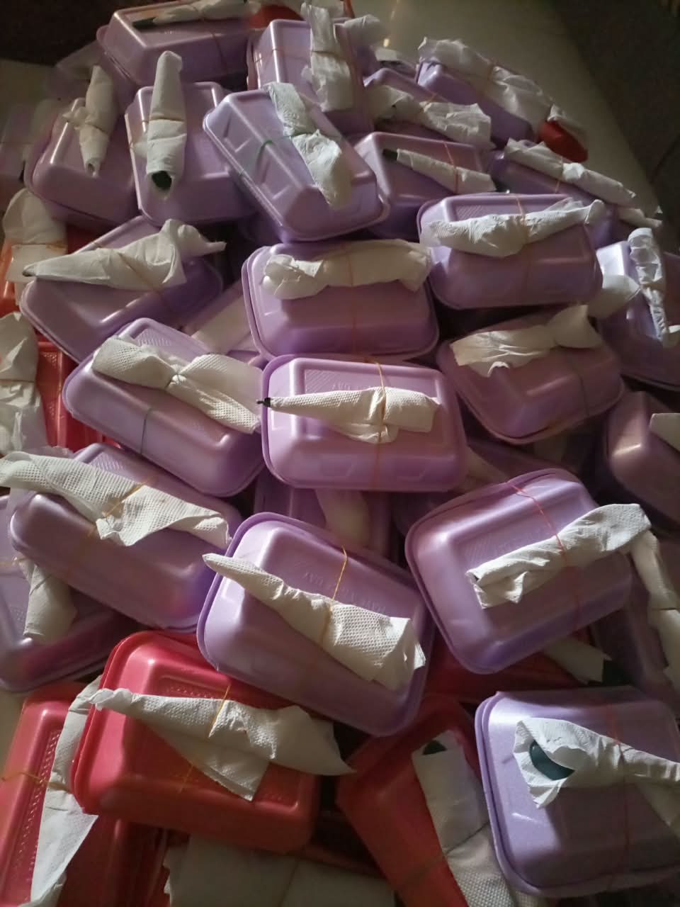 Close-up of packed hot meals, each tied with wrapped cutlery