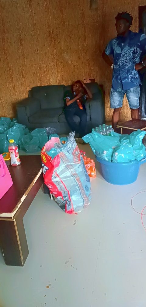 Volunteers preparing bagged provisions, rice and drinks indoors before an outreach